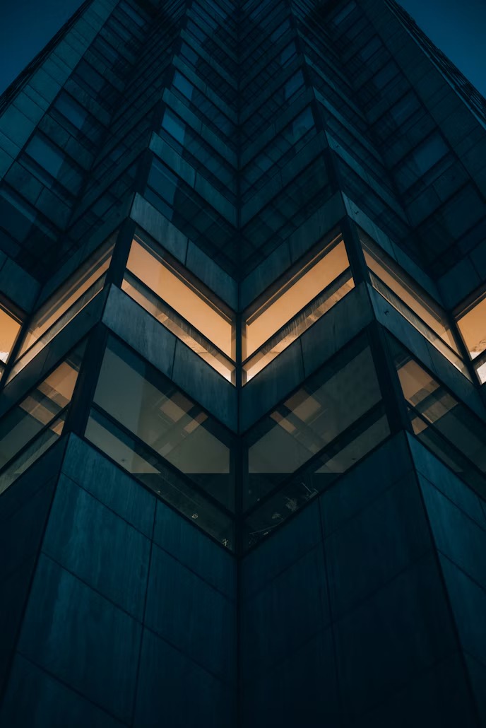 Glass tower at dusk with lit windows